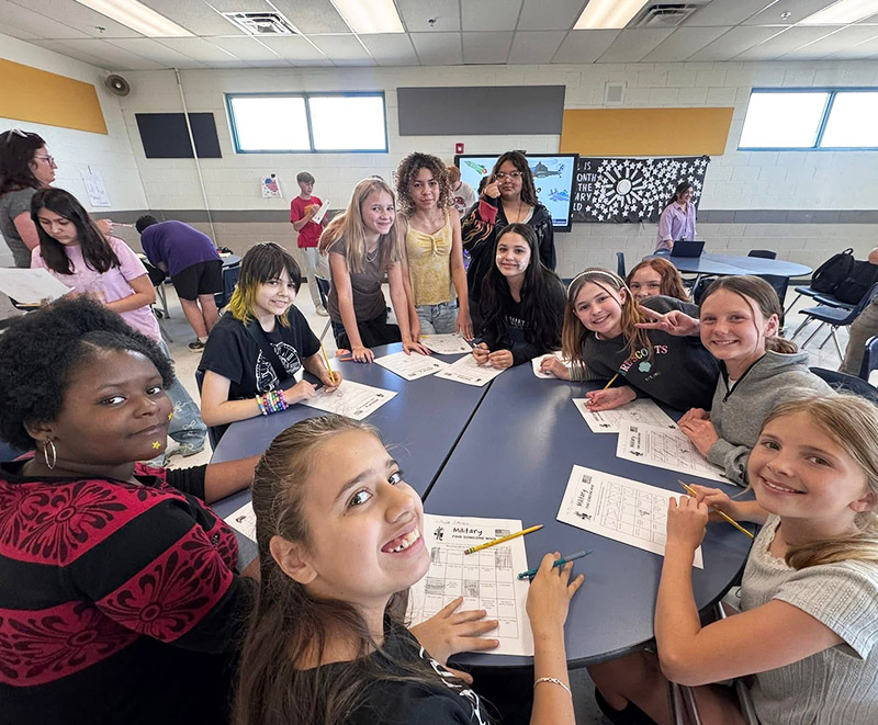 Group of happy students and adults in a classroom