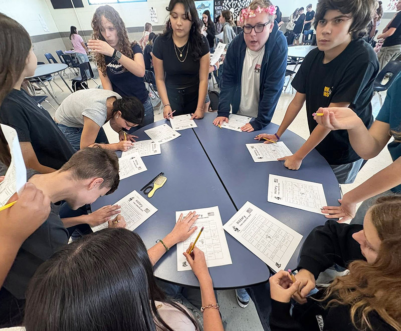 Group of students working on a project around a round table