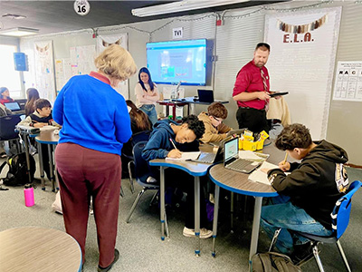 Adults watching students do classwork