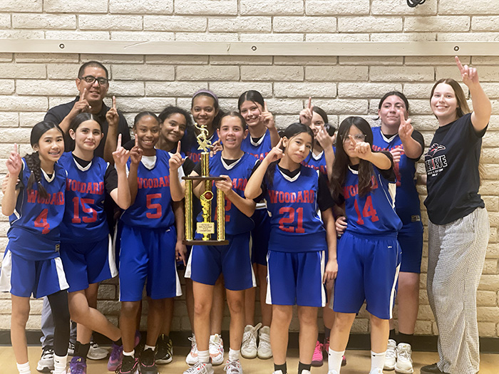 Girls basketball team holding up a big trophy