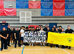 Students behind a sign that reads We love our Yuma county officers
