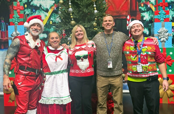 TUHSD staff member dressed in holiday attire on a stage