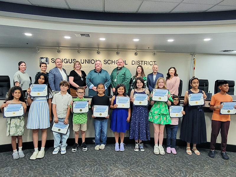 Happy students receiving a Cooperation Award during a board meeting