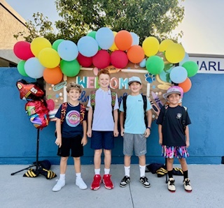 Four boys smiling for the camera on the first day of school