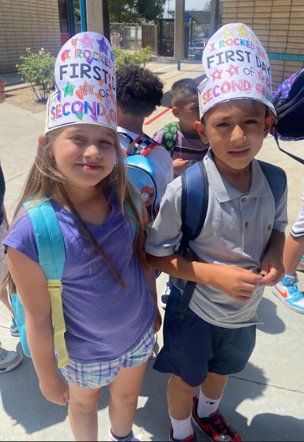 Two happy students wearing first day of school hats