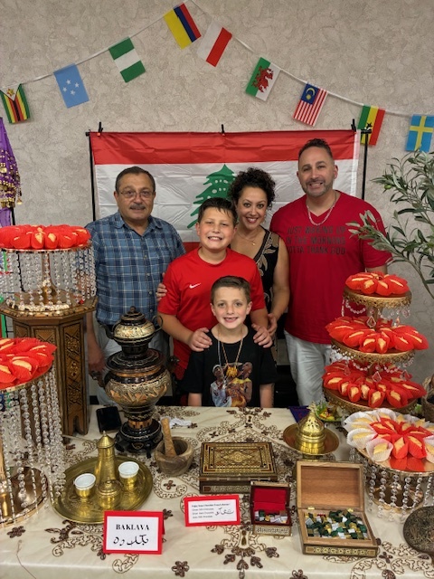 Group of adults and students behind a beautiful display table