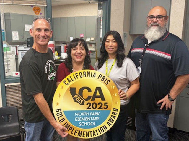 Four staff members at North Park holding California PBIS 2025 Gold award