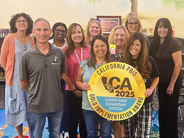 Group of happy North Park staff members happily holding California PBIS 2025 Gold award