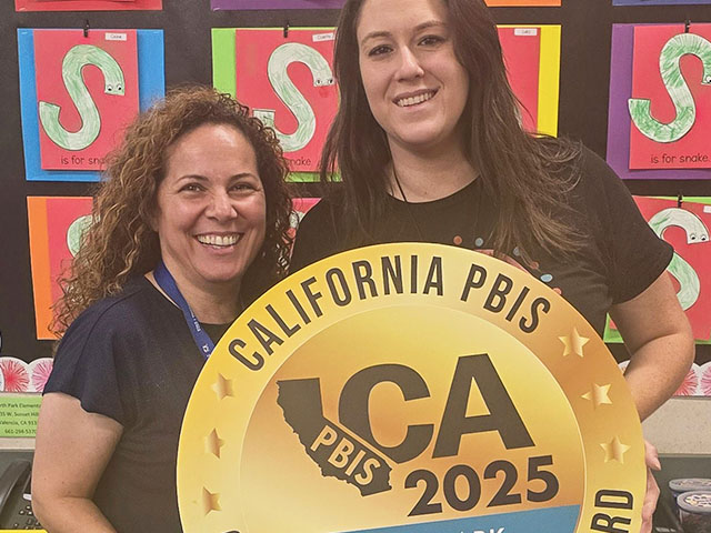 Two North Park staff members happily holding California PBIS 2025 Gold award