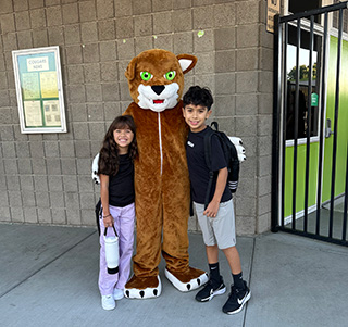 Two students posing with the Cedarcreek mascot
