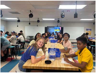 Students working on Science Summer Camp projects at tables