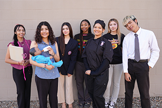 Teacher with students holding a baby doll