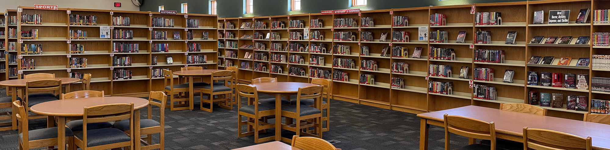 Tables and chairs surrounded by library bookshelves