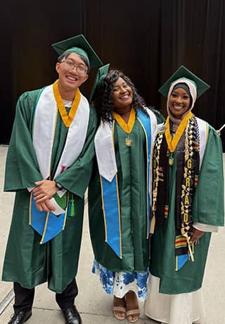 Three smiling graduating students