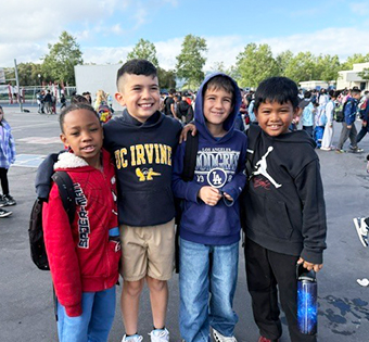 Four happy students outside posing for a picture