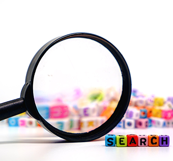 Magnifying glass with SEARCH in colorful blocks