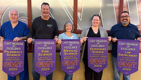 People holding Cavit Program of Excellence banners