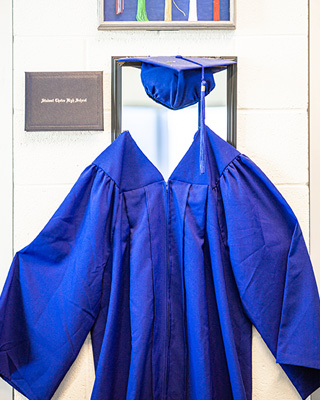 cap and gown hanging on mirror