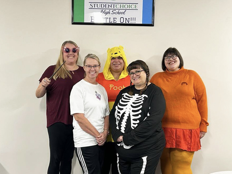 Group of five women in costumes smiling for the camera