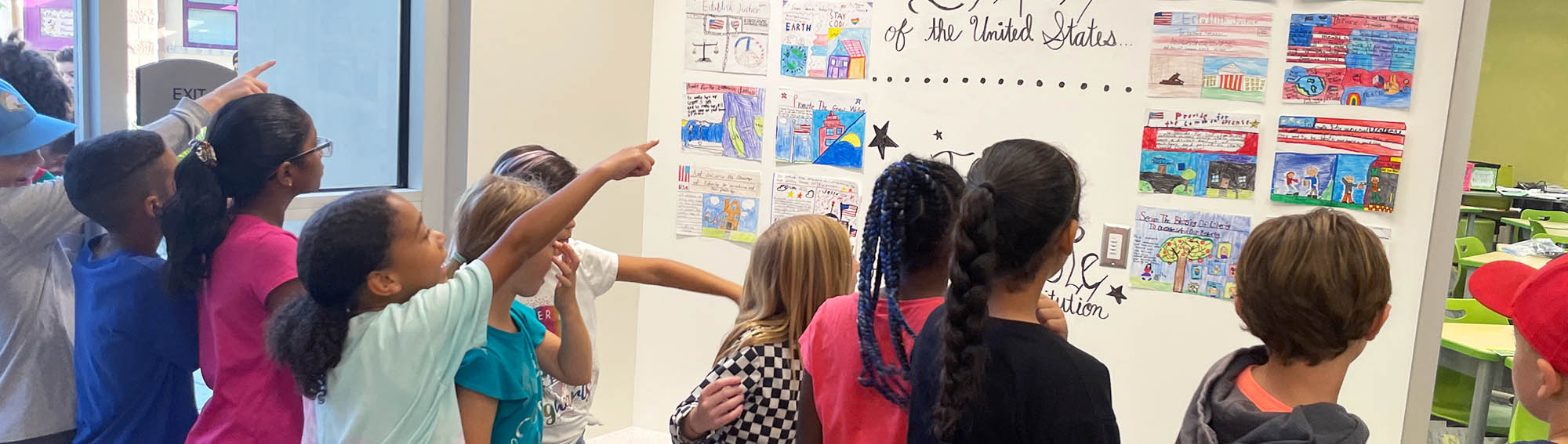 Students admiring and pointing to patriotic student artwork