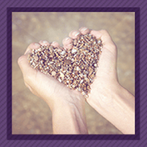 Hands holding small pebbles in the shape of a heart