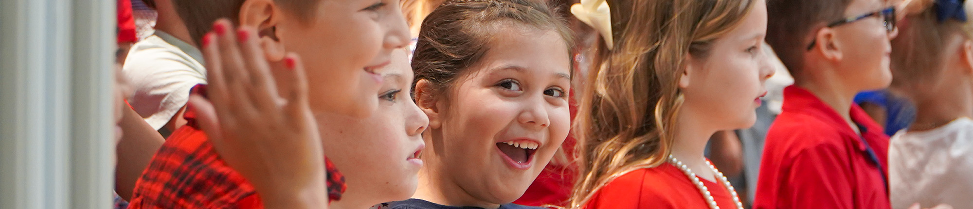 Group of happy elementary students wearing red outfits