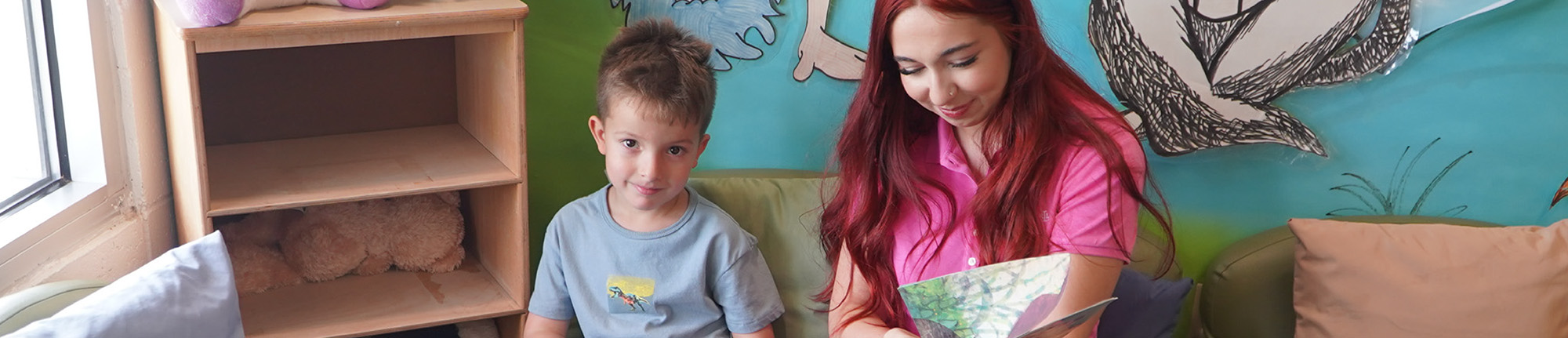 Preschool teacher next to happy student