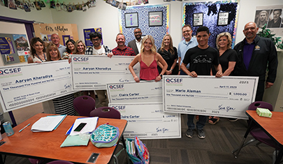 QCSEF members holding up huge checks