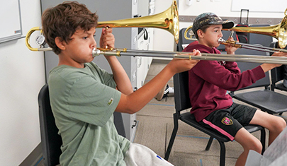 Two students playing horned instruments