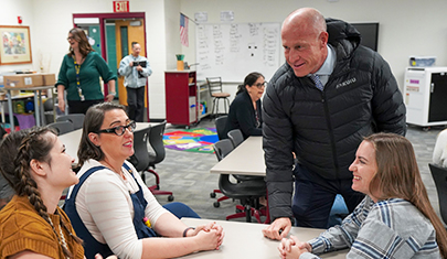 Dr. Berry talking with some women at a table
