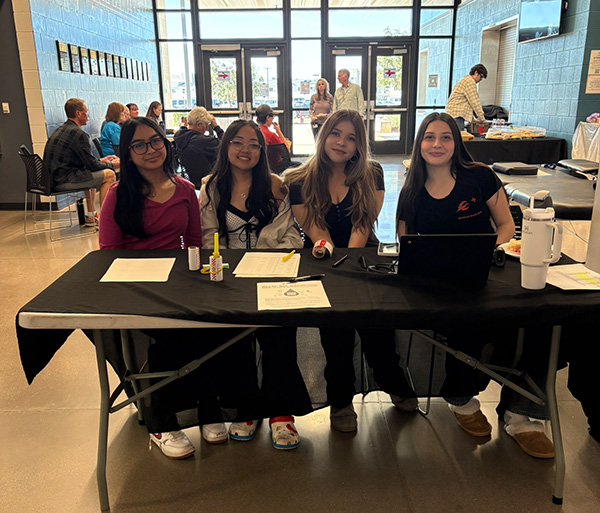 Four female students sitting at a display table