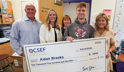 Aidan Brooks holding a large scholarship check
