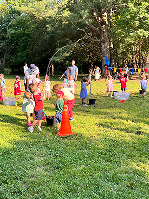 Kids playing with water pistols at the end-of-the-year picnic