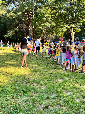 Two teams of children engaged in a tug-of-war at the end-of-the-year picnic