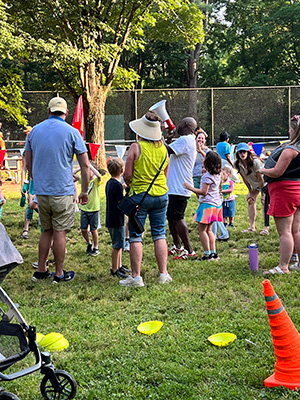 Children getting ready for a game while their families watch