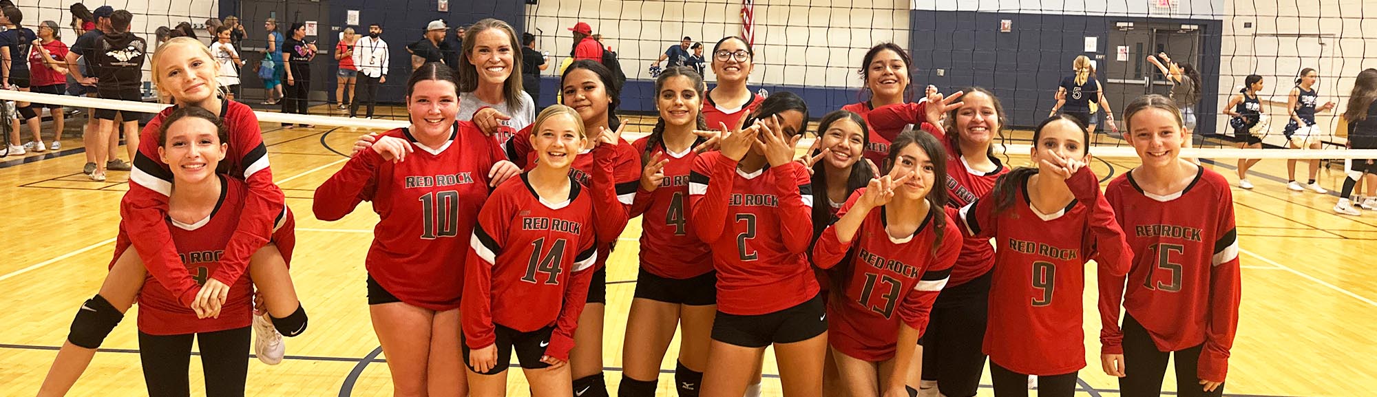 Students with parachute in gym Group of happy girls volleyball team on the court