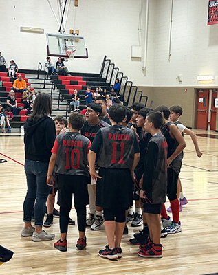 Boys basketball team in a huddle on the court