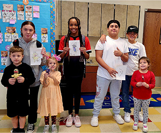 Group of students holding up awards