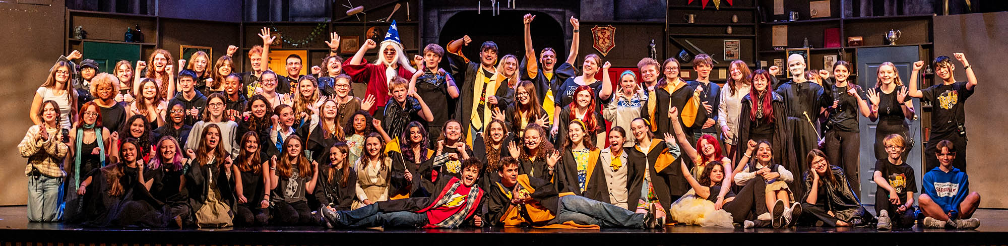 Student actors on a stage smiling for the camera