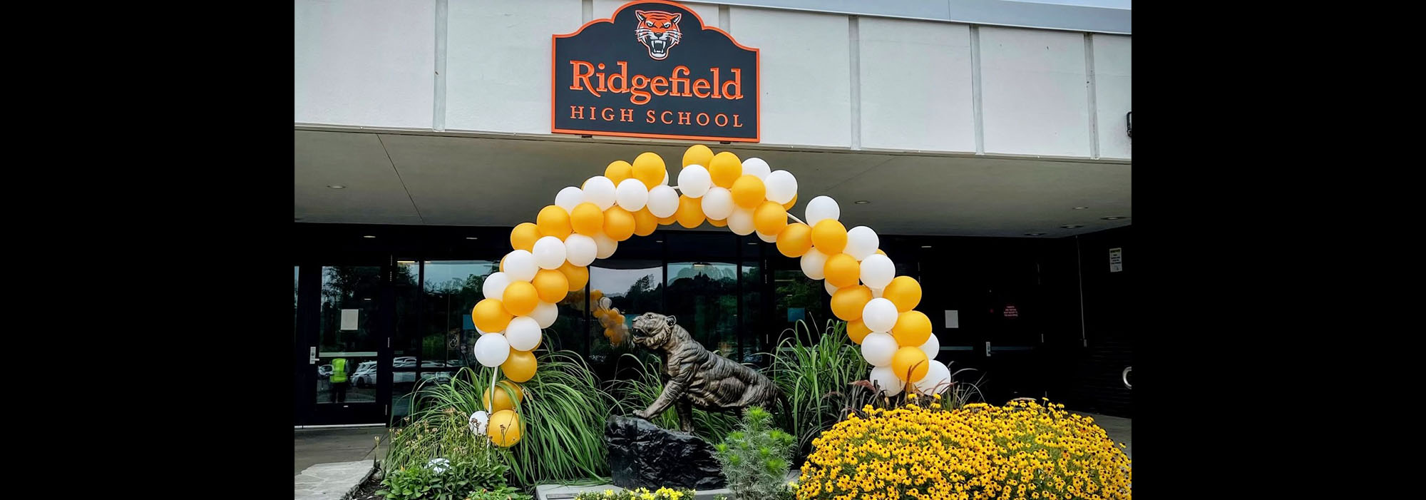 Front of Ridgefield High School building with bronze tiger and balloons