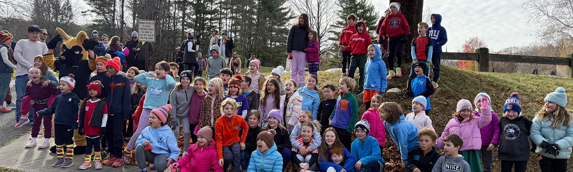 Group of students outside with school mascot on a chilly day