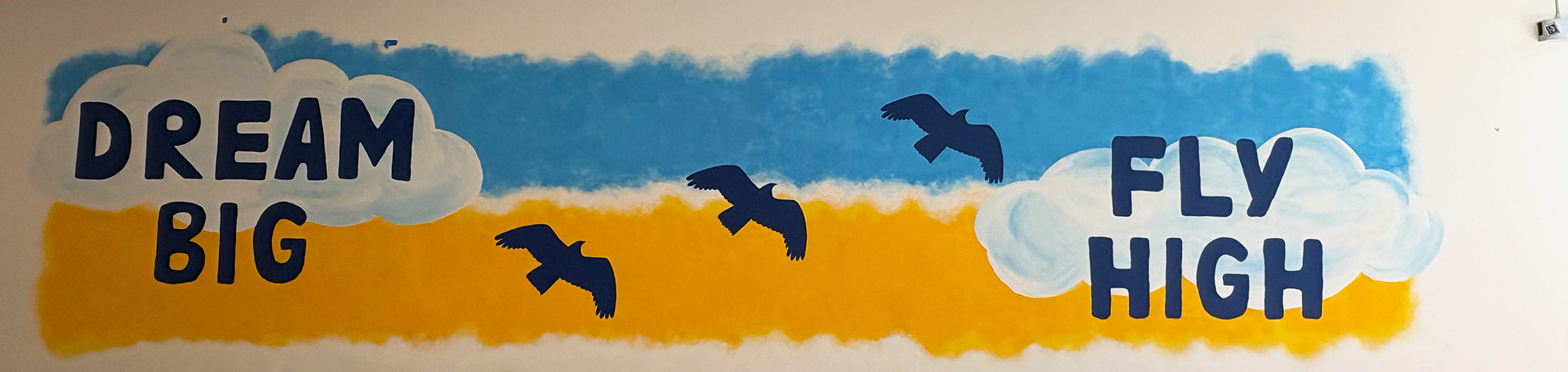 Dream Big, Fly High blue and gold mural with birds