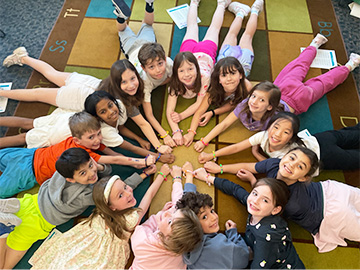 Group of happy students with hands arranged in a circle
