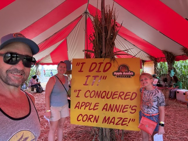 Superintendent next to Corn Maze poster