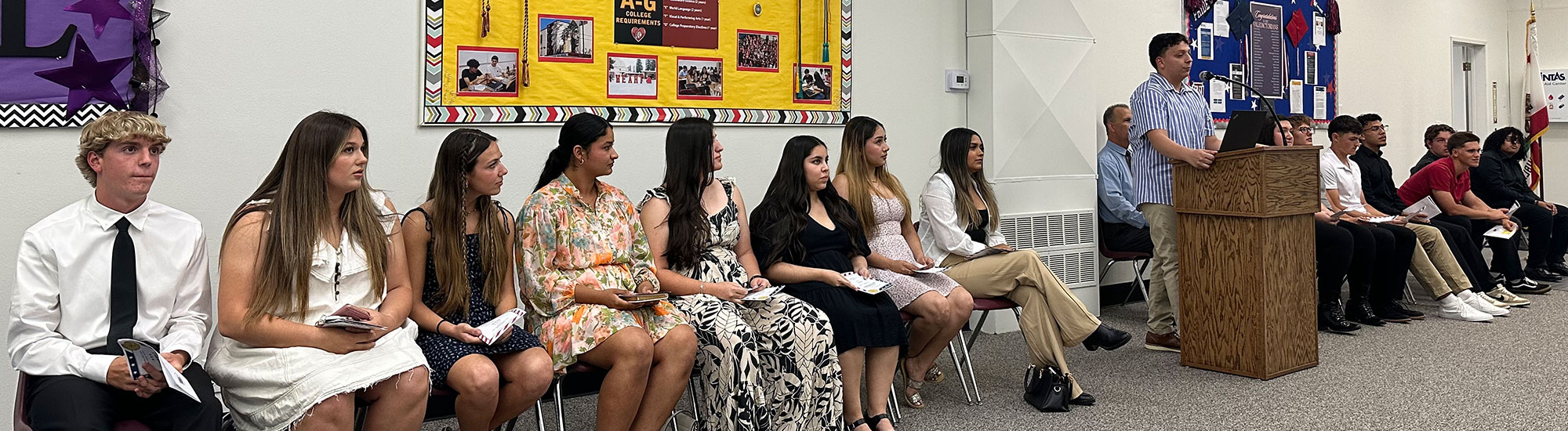 Students sitting in chairs along the wall for speeches Students sitting in chairs along the wall for speeches