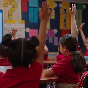 kids raising hands in class