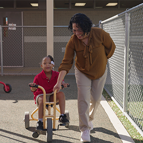 teacher helping student on bicycle