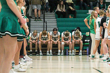 Girls basketball team sitting on bench