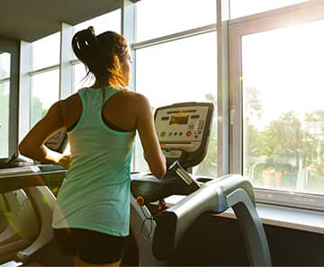 person looking out the window while running on a treadmill