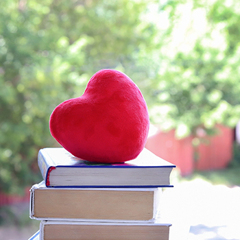 Red heart on top of stack of books